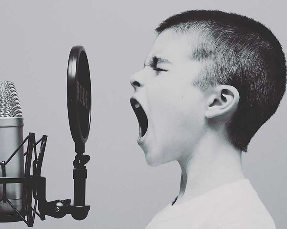 ragazzino canta attraverso il microfono